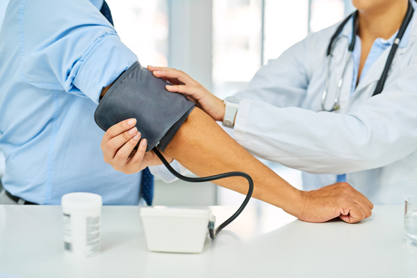 Doctor taking patient's blood pressure